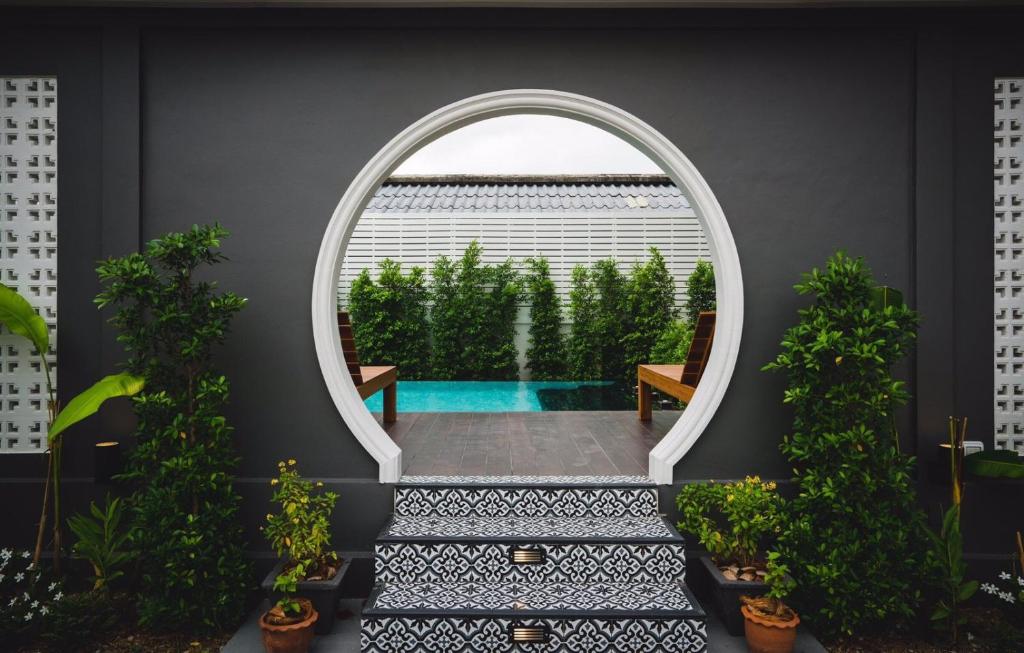 an arched window with a view of a swimming pool at The Besavana Phuket - SHA Extra Plus in Phuket Town