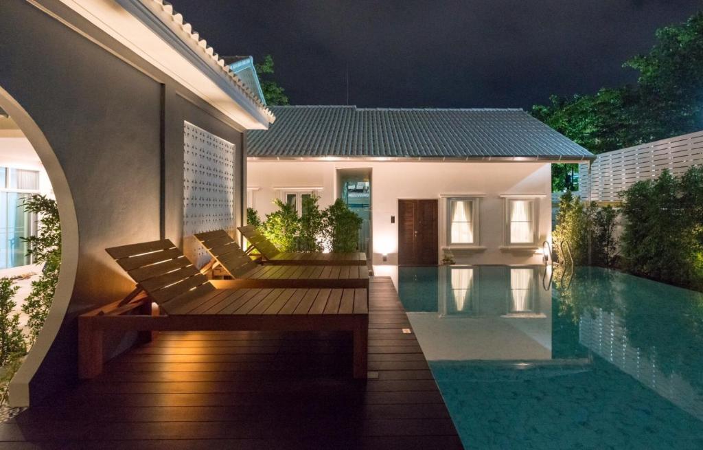 a villa with a swimming pool at night at The Besavana Phuket - SHA Extra Plus in Phuket Town