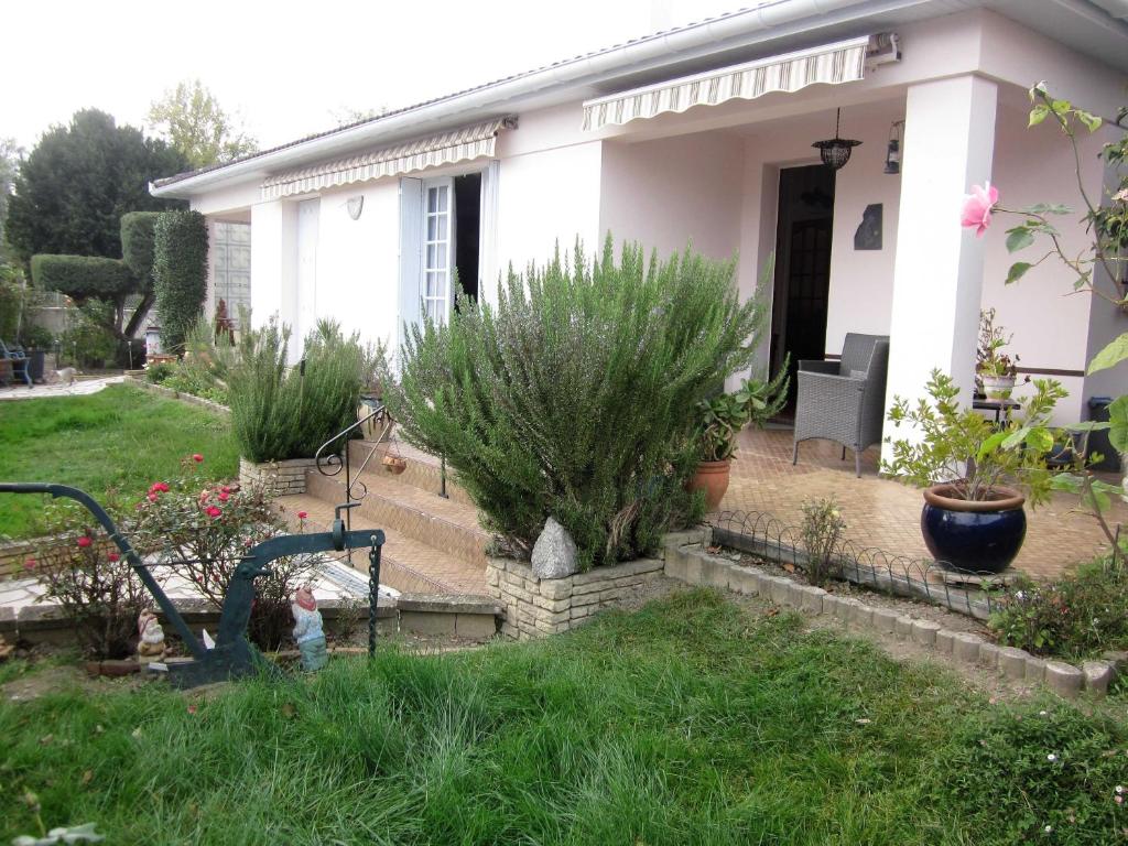 une maison blanche avec quelques plantes dans la cour dans l'établissement BORD' ADOUR, à Soues