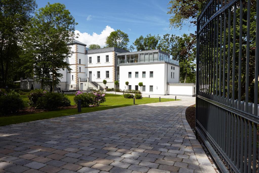 an entrance to a white house with a brick driveway at Hotel Rittergut Stoermede in Geseke