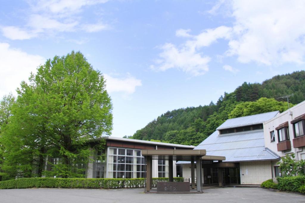 un gran edificio con una montaña en el fondo en Kasuga no Mori, en Saku