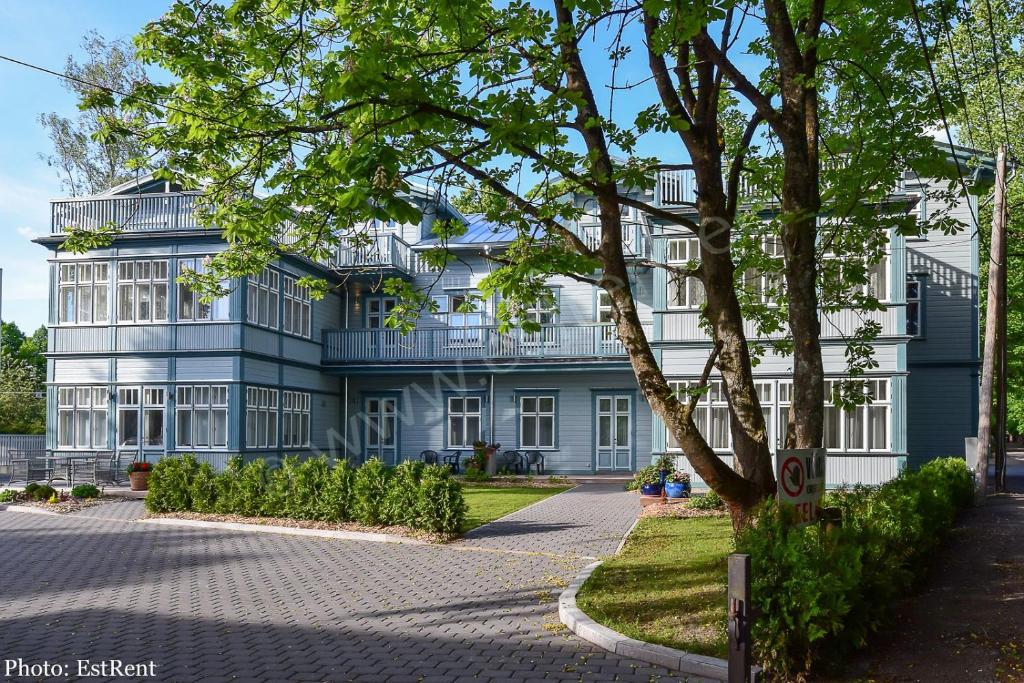 a blue building with a tree in front of it at Austri Villa in Pärnu