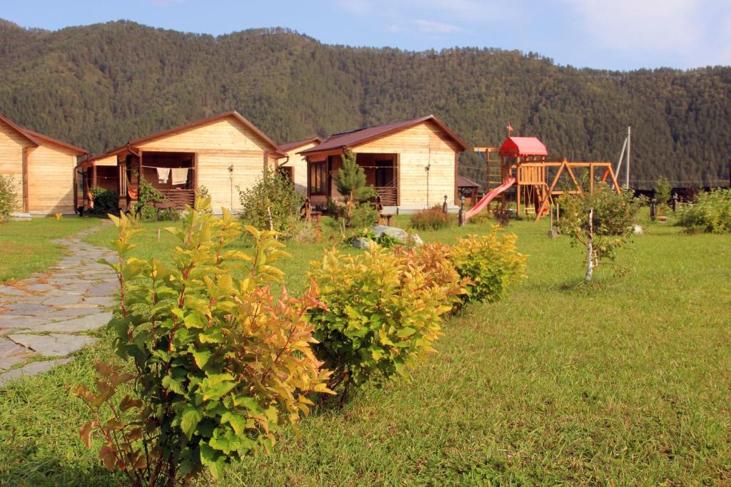 a row of houses in a field with bushes at Baza otdykha AltayRay in Elekmonar