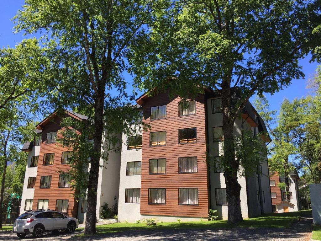 un edificio de apartamentos con fachada de madera en Departamento Pucón, en Pucón