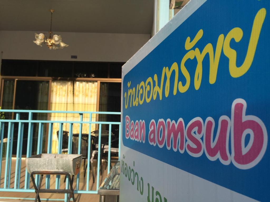 a sign for a synagogue with a table and a chair at Baan AomSub in Ko Samed
