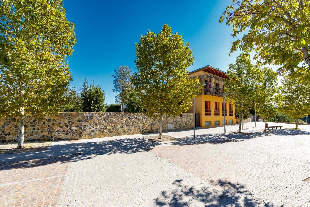 un patio de ladrillo con árboles y un edificio en Le Scuole B&B - by ColleMassari Hospitality en Cinigiano