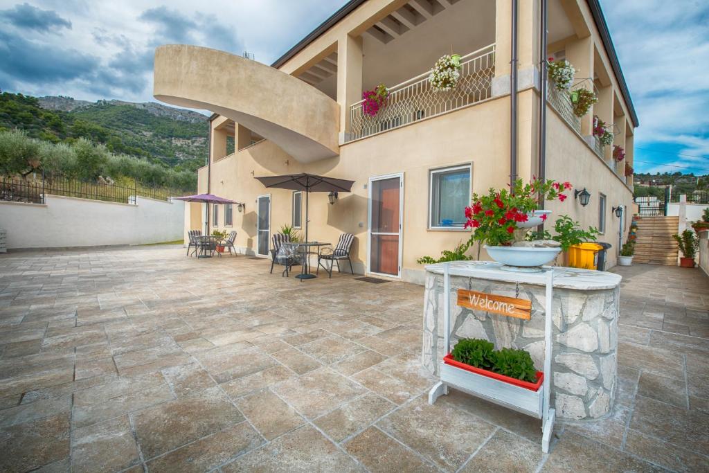 een patio van een huis met een tafel met bloemen bij La Finestra sul Mare Locazione Turistica in Monte SantʼAngelo