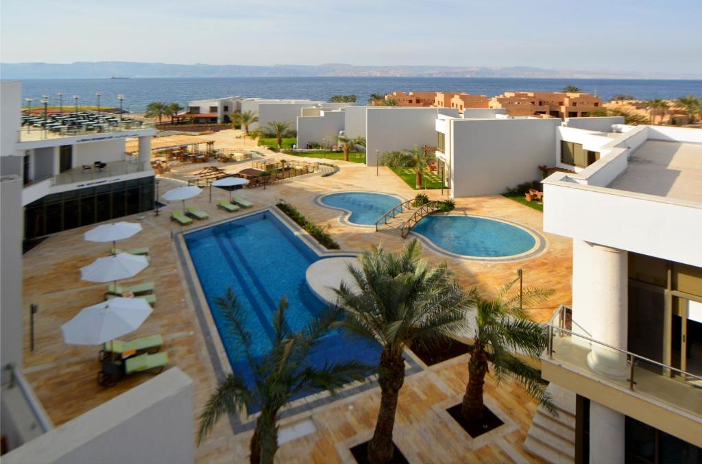 an aerial view of a resort with two pools and palm trees at Public Security Hotel & Chalets in Aqaba