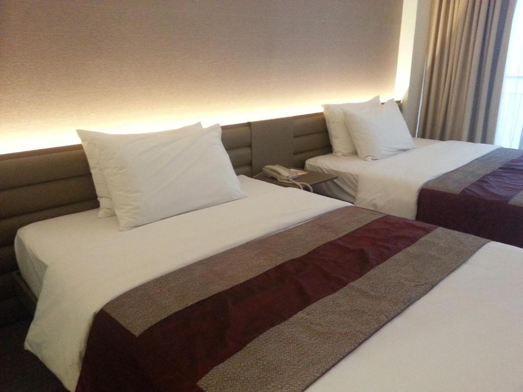 Tempat tidur dalam kamar di The E-Hotel Makati