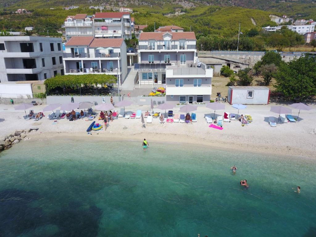 - une vue aérienne sur une plage avec des personnes dans l'eau dans l'établissement Seaside Luxury Suites, à Podstrana