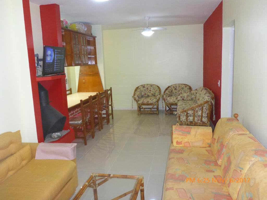 a living room with a couch and chairs and a table at Apartamento Capão Novo in Capão da Canoa
