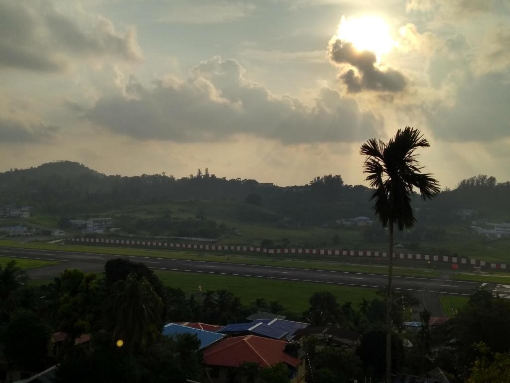 a palm tree with the sun in the sky at The Lagoon shade in Port Blair