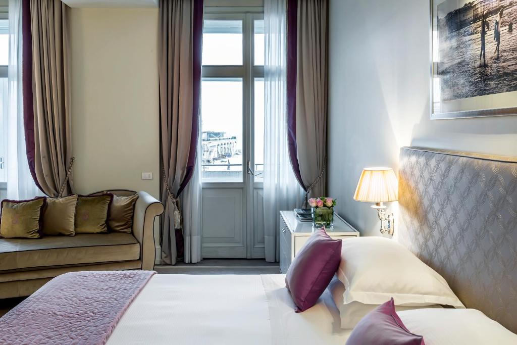 a hotel room with a bed and a couch at Savoia Excelsior Palace Trieste - Starhotels Collezione in Trieste