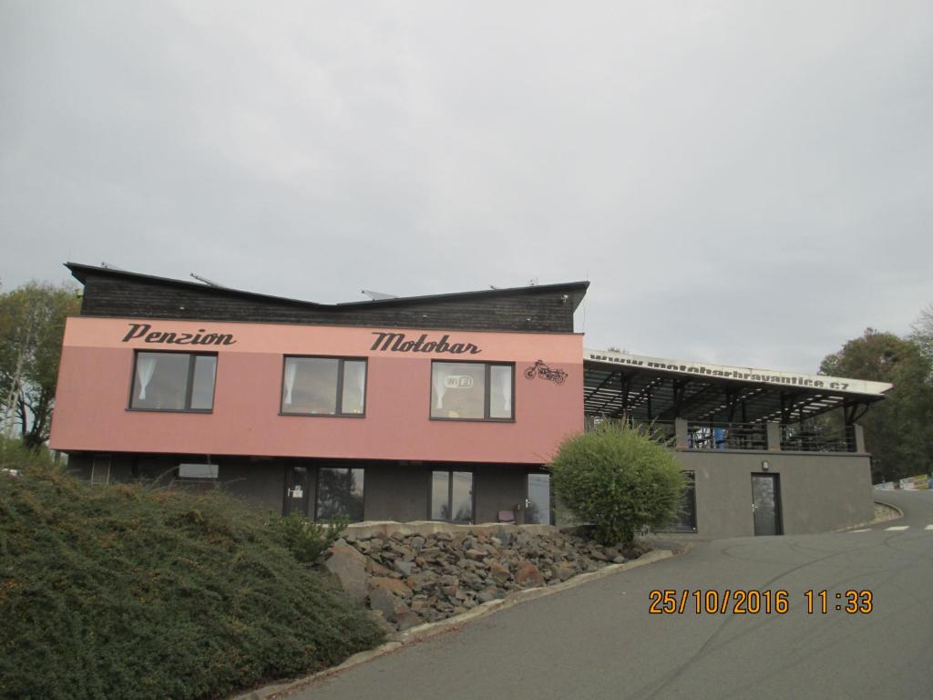 a pink building with the word tribune on it at Penzion a Motobar Bravantice in Bravantice