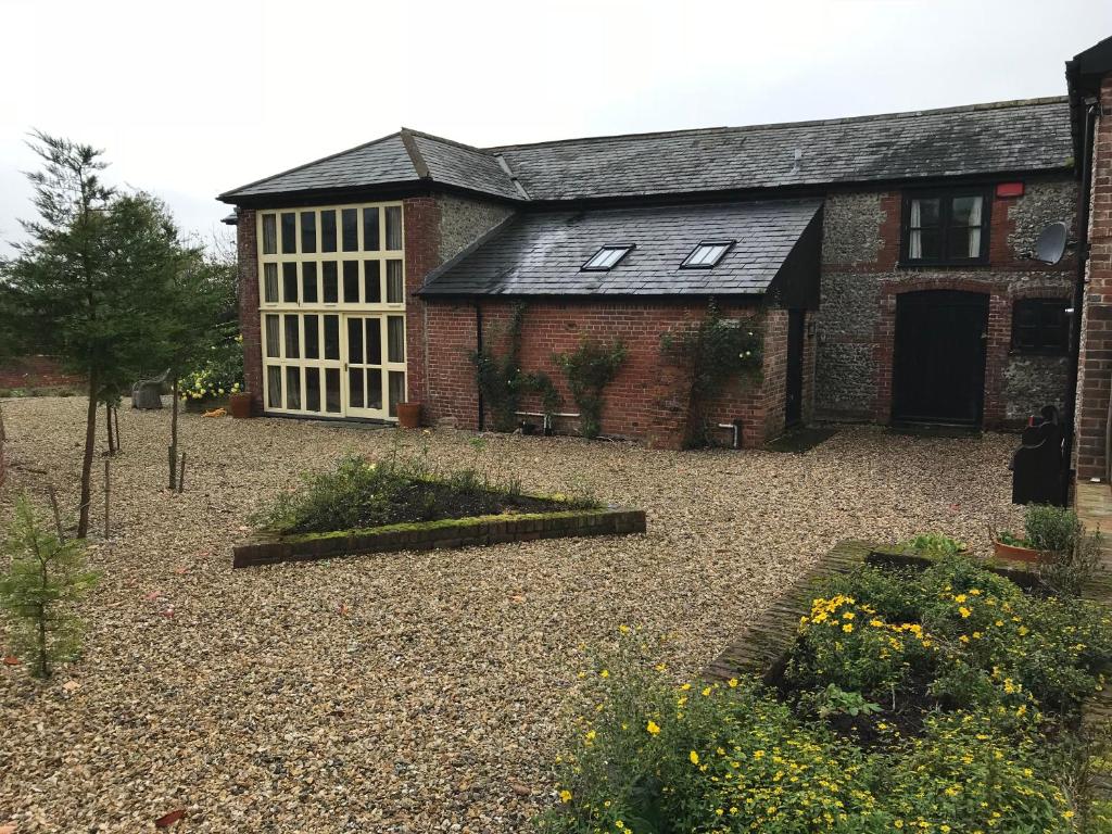 a brick house with a large courtyard in front of it at Pleck Barn B&B in Ansty