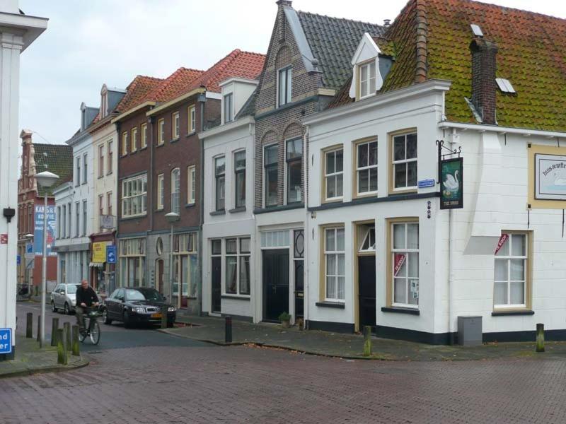 een groep gebouwen in een stadsstraat bij De Zilveren Karper in Kampen