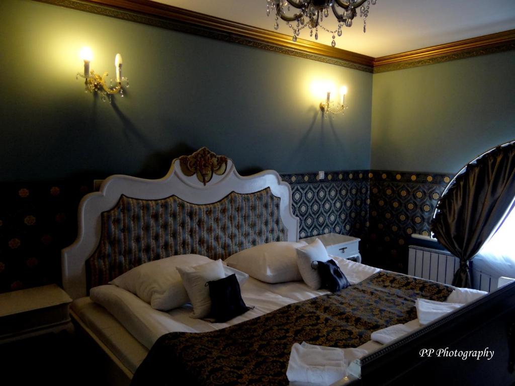 a bedroom with a white bed with pillows at Willa Kraj in Ustroń