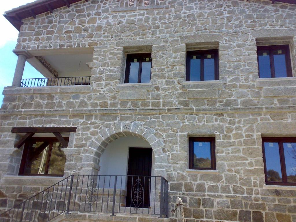 einem externen Blick auf ein Steinhaus mit einem Balkon in der Unterkunft Casa Rural del Médico I y II in Herradón de Pinares