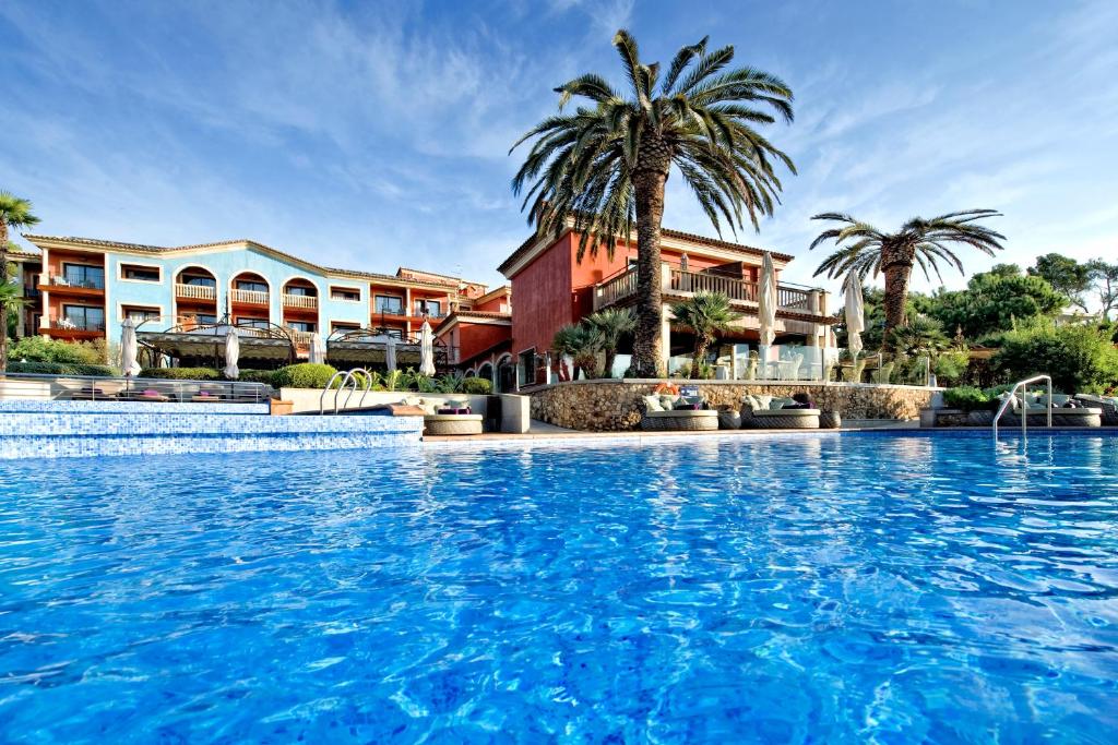 a large swimming pool in front of a large building at Hotel Cala del Pi - Adults Only in Platja d'Aro
