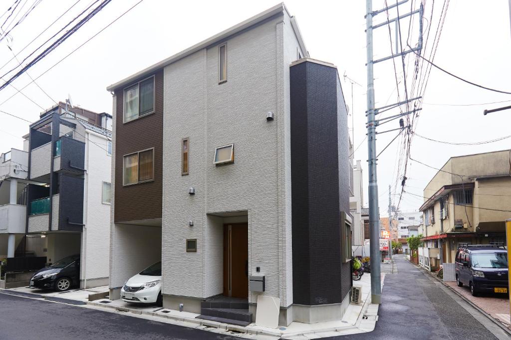 um edifício numa rua com carros estacionados em frente em Haneda Luxury House em Tóquio
