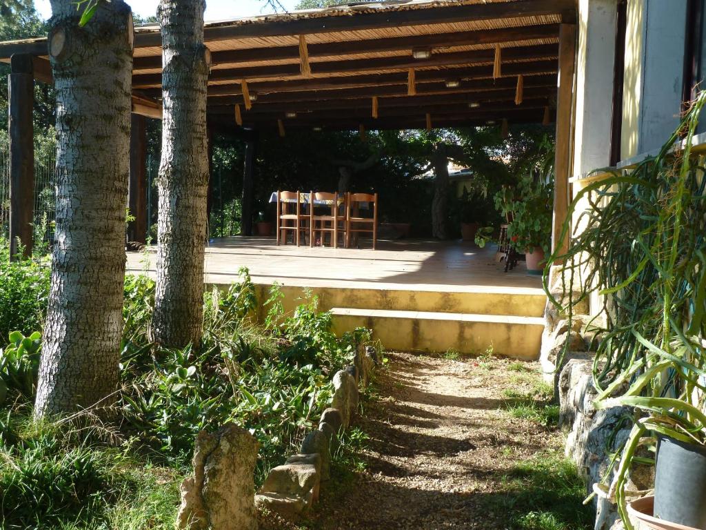 une terrasse couverte d'une maison avec une table et une chaise dans l'établissement Agriturismo Vaddidulimu, à Luogosanto