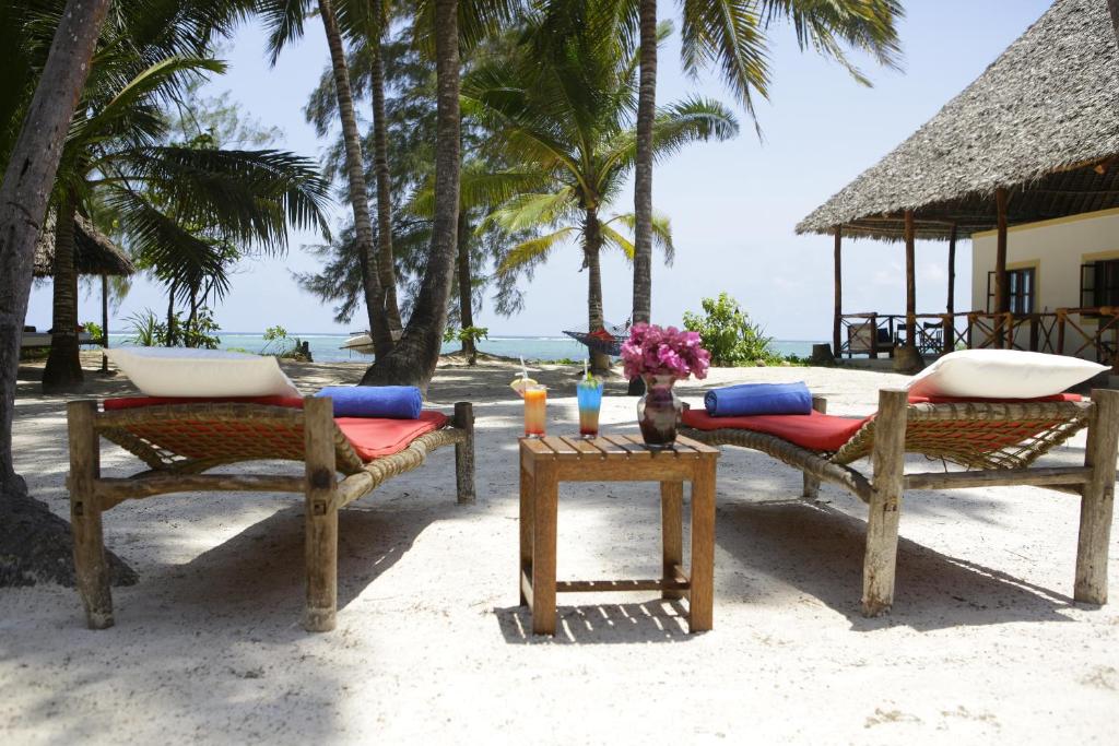two chairs and a table on the beach at Panga Chumvi Beach Resort in Matemwe