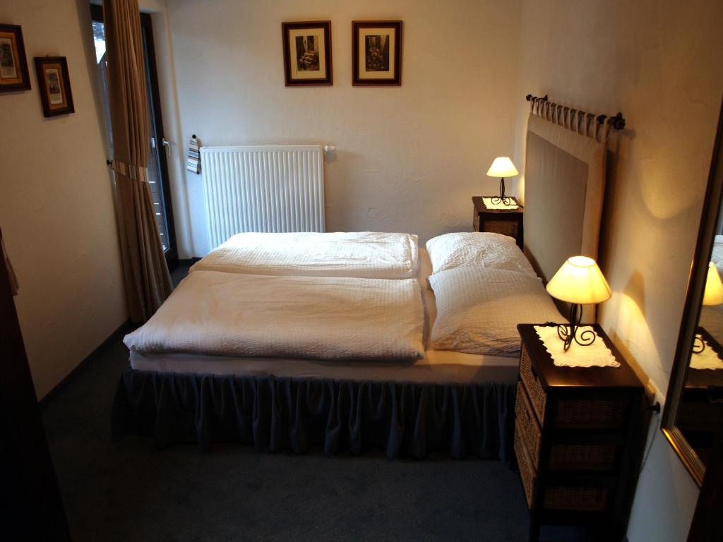 ein Schlafzimmer mit einem Bett, zwei Lampen und einem Spiegel in der Unterkunft Apartment Kärntnerhaus I in Patergassen