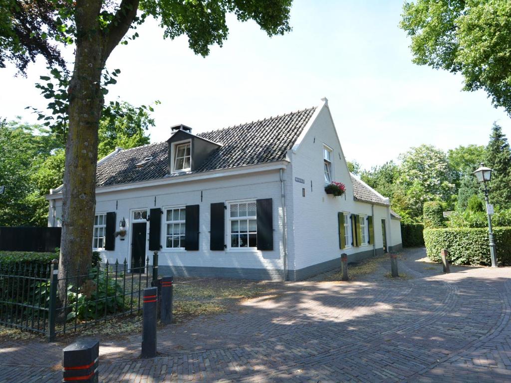 une maison blanche avec un arbre en face dans l'établissement Huys en Hoff Aen Den Haspel, à Oirschot