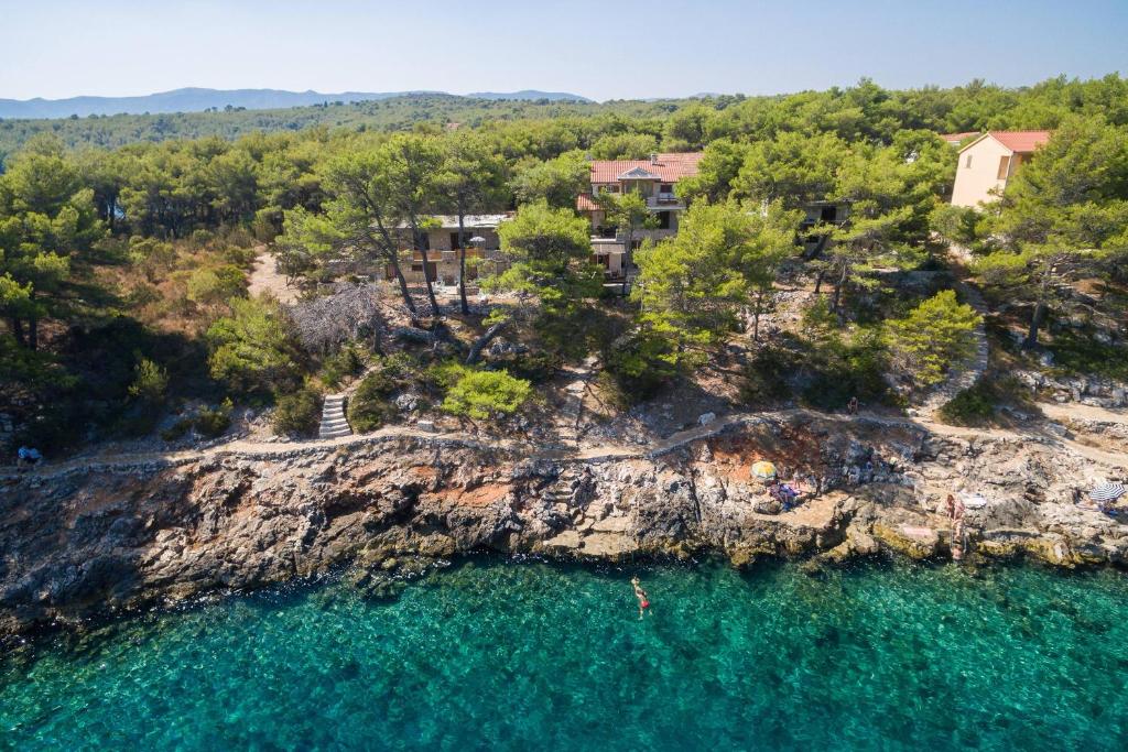 una vista aérea de una casa en una isla rocosa en el agua en Pavao Apartments, en Vrboska