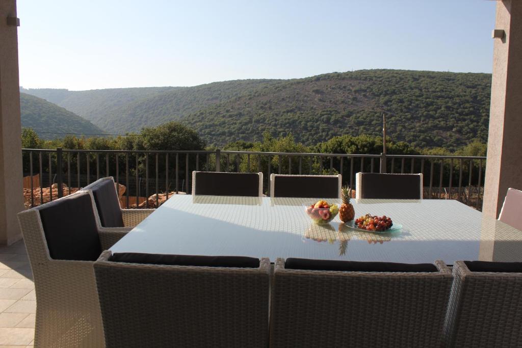 a table and chairs with a view of a mountain at Habait ba Shomera in Shomera