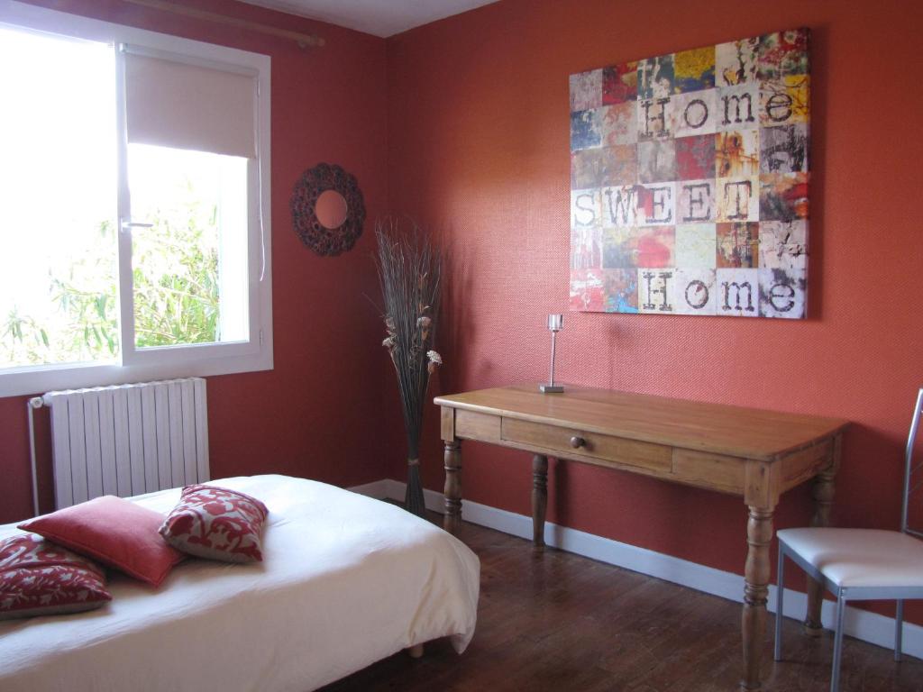 Schlafzimmer mit einem Bett und einem Holzschreibtisch in der Unterkunft Gîte "Au Gré de l'Adour" in Aire-sur-lʼAdour