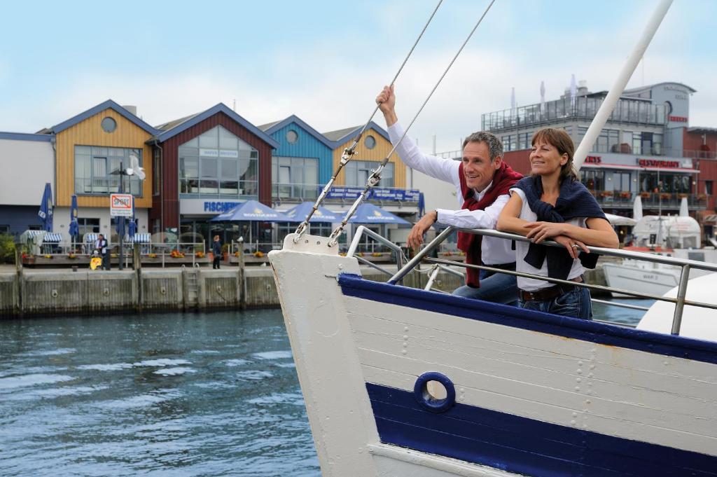a man and woman on a boat in the water at Hotel Neptun in Warnemünde
