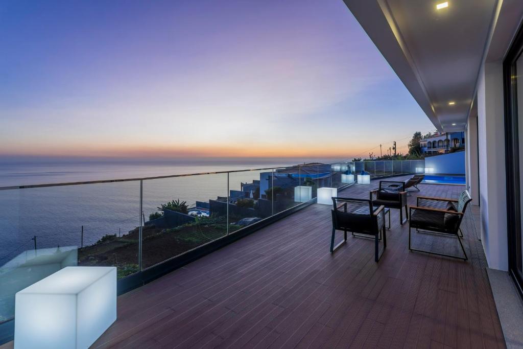 un balcón de una casa con vistas al océano en Searenity Vacation Home I by An Island Apart, en Arco da Calheta