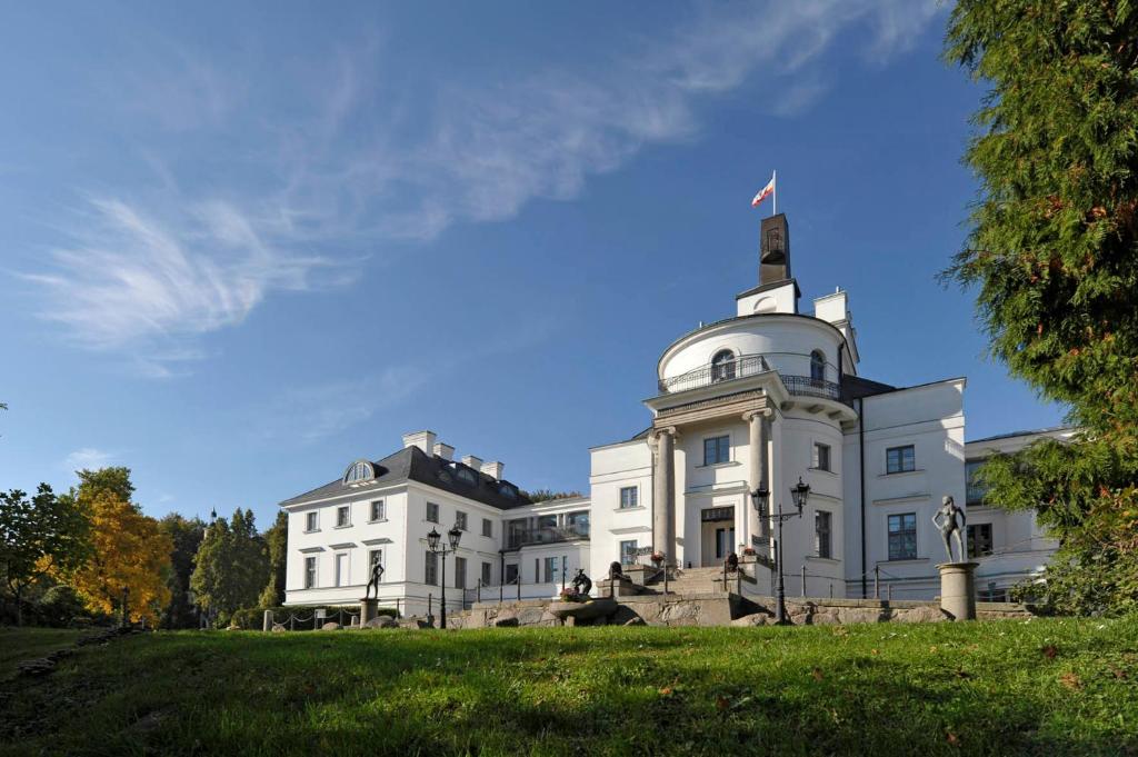 a white building with a flag on top of it at Schlosshotel Burg Schlitz in Hohen Demzin