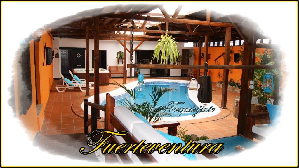 Villa Spa Las Tinajas في Triquivijate: مسبح وزحليقة في بيت