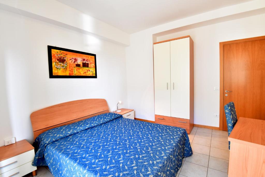 a bedroom with a bed with a blue comforter at Hotel Villa Olga in Caorle