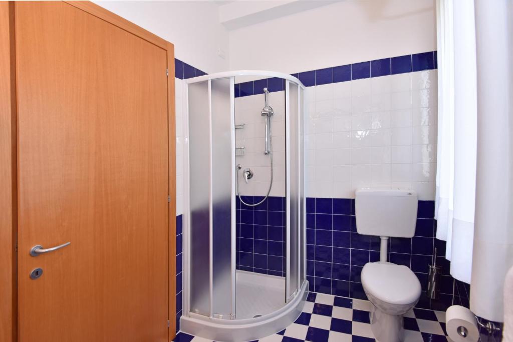 a bathroom with a toilet and a glass shower at Hotel Villa Olga in Caorle