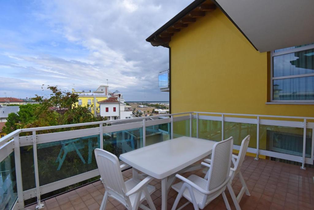 a balcony with a white table and chairs on it at Hotel Villa Olga in Caorle