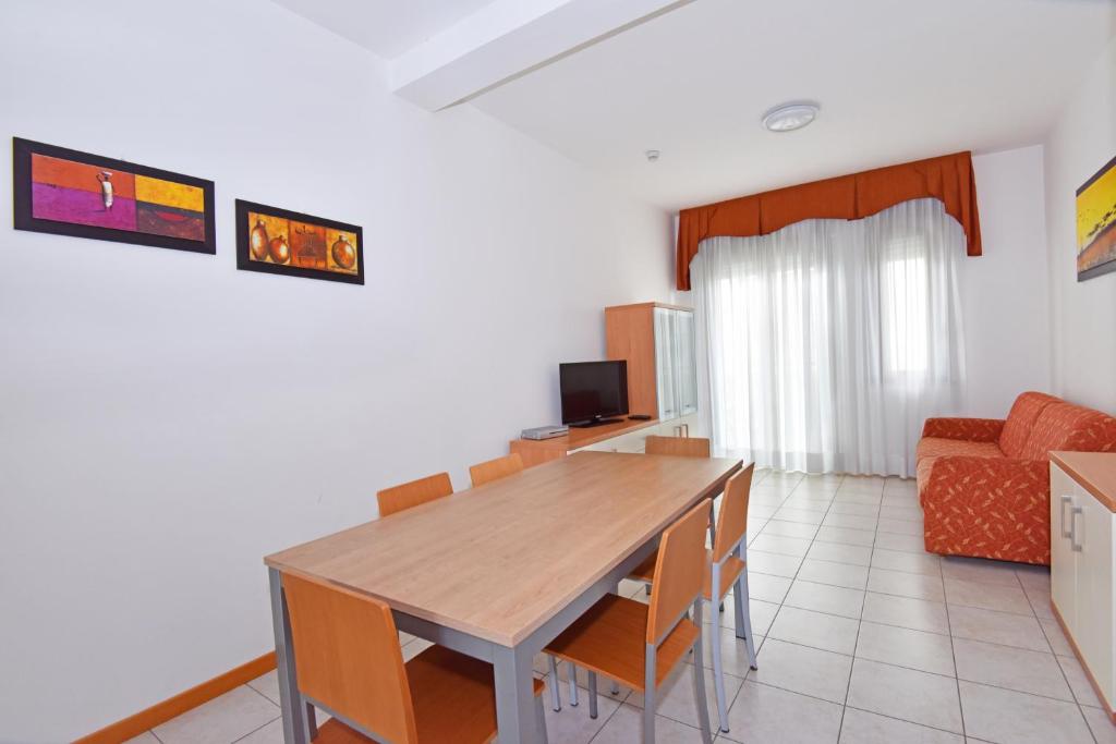 a living room with a wooden table and chairs at Hotel Villa Olga in Caorle
