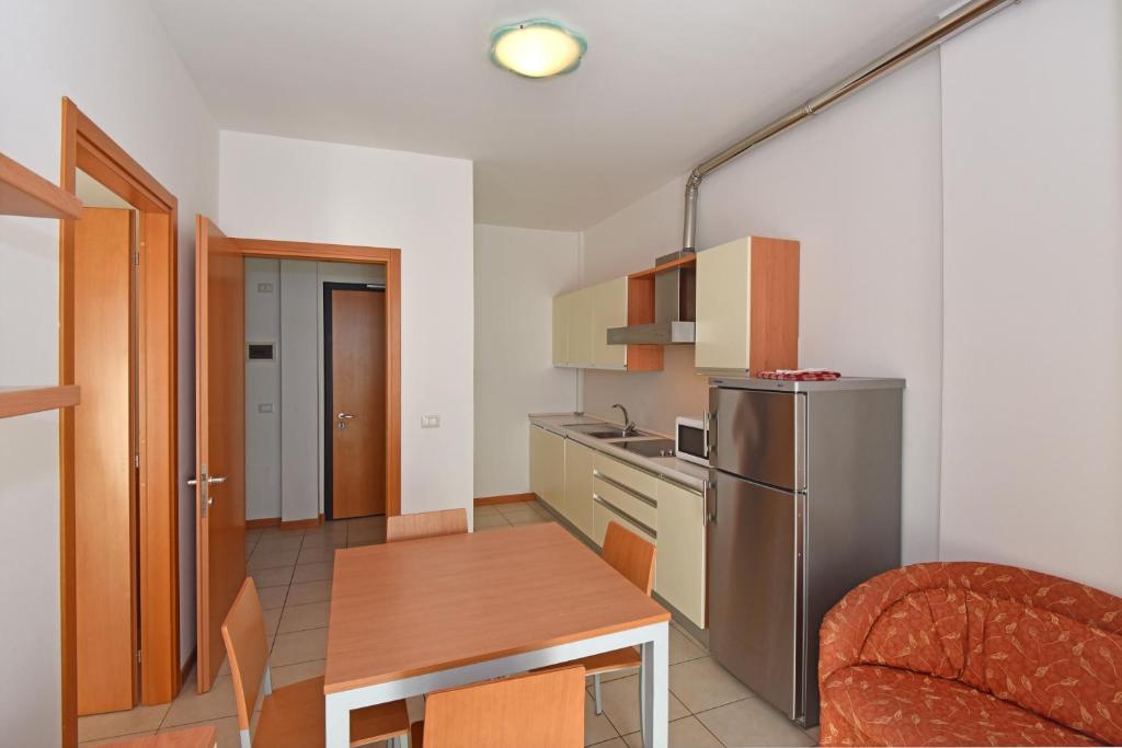a small kitchen with a table and a refrigerator at Hotel Villa Olga in Caorle