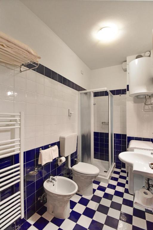 a bathroom with a toilet and a shower and a sink at Hotel Villa Olga in Caorle