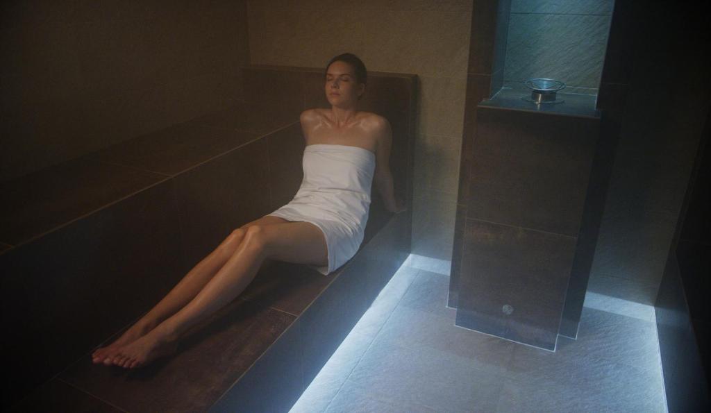 a woman laying on the floor in a bath tub at Hotel Cliff Belvedere in Izola