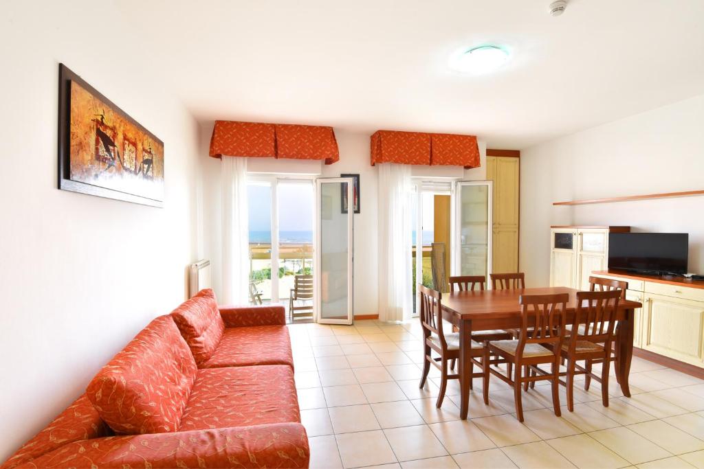 a living room with a couch and a table and chairs at Hotel Villa Olga in Caorle