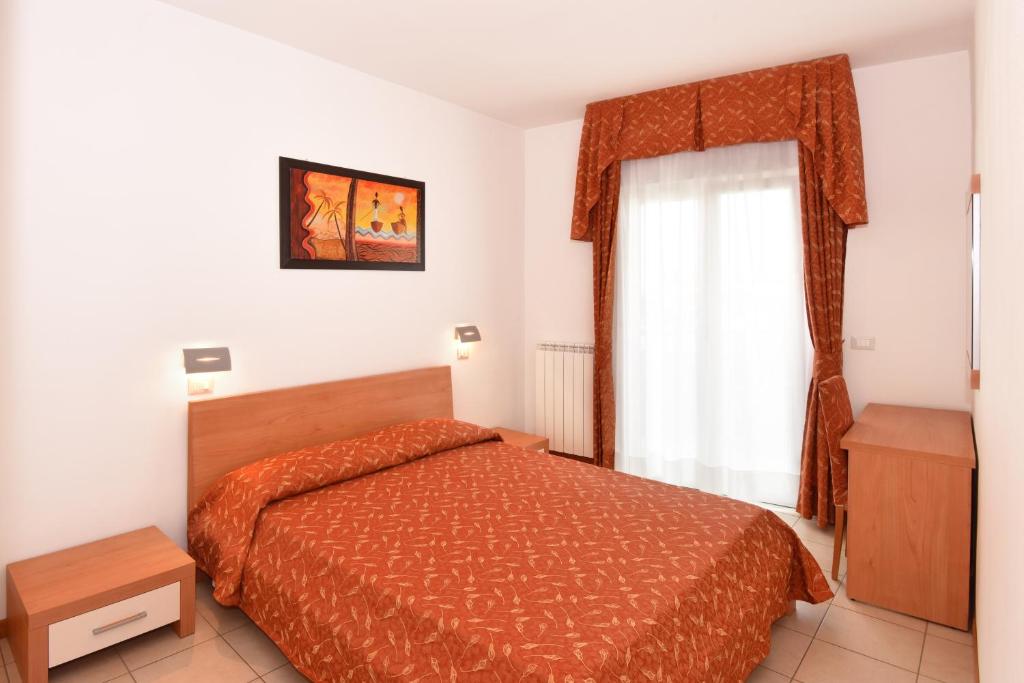 a bedroom with a bed and a window at Hotel Villa Olga in Caorle