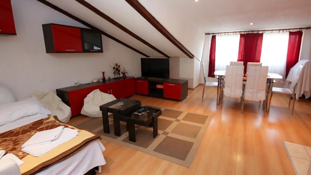 Una sala de estar con una cama y un comedor. en Apartment Ajdukovic 2, en Vodice