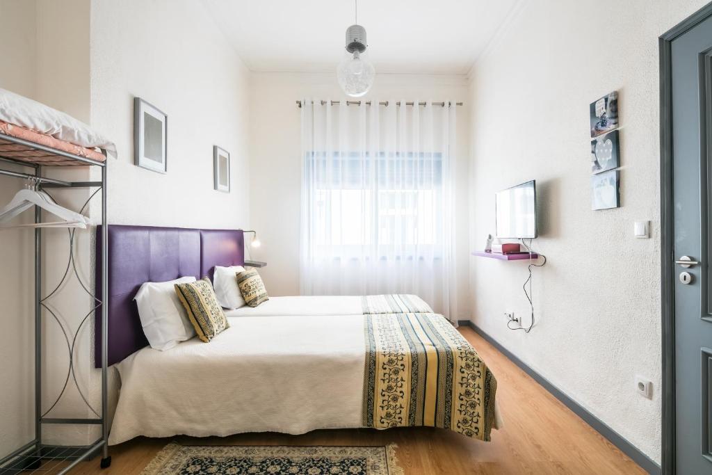 een slaapkamer met een bed en een raam bij Apartamento Purple Room in Porto