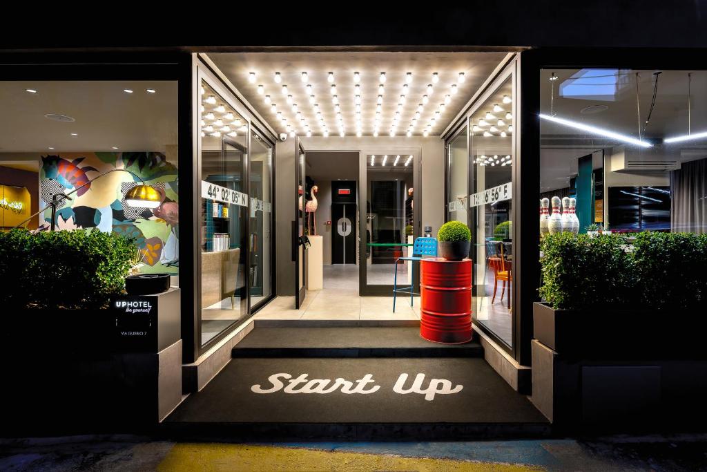 a store front with a sign that says start up at Up Hotel in Rimini