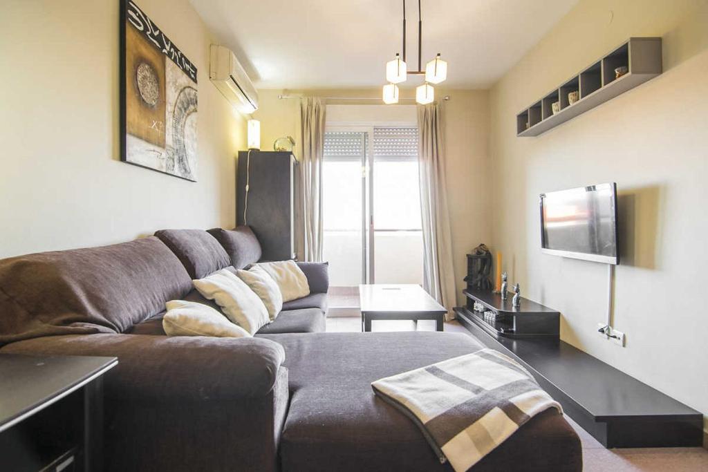 a living room with a couch and a tv at Apartamento Alcalá Real in Granada