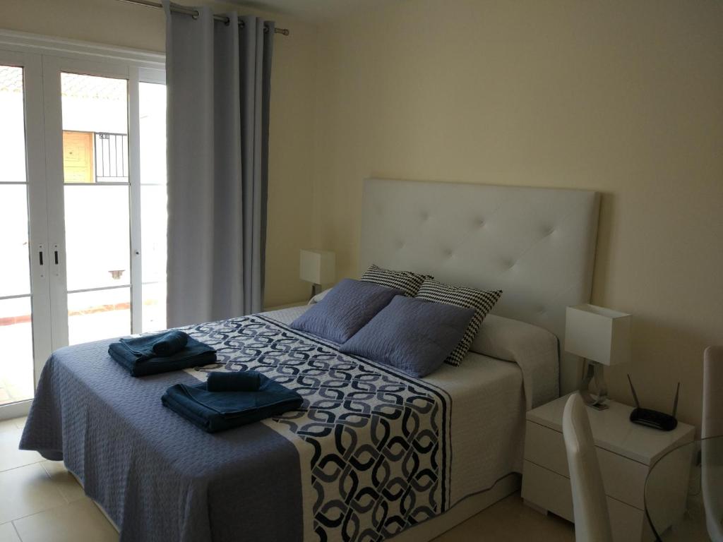 a bedroom with a bed with blue towels on it at Los Cristianos studio, modern, spacious, pool,WiFi in Arona