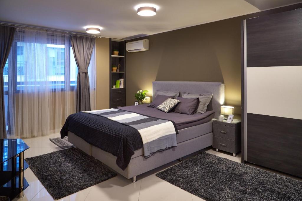 a hotel room with a bed and a dresser at City Center Apartments in Plovdiv